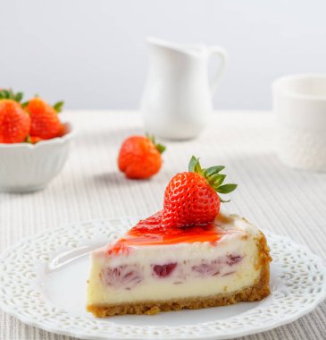 Çilek beyaz duvara bir tablo ile lezzetli peynirli kek.