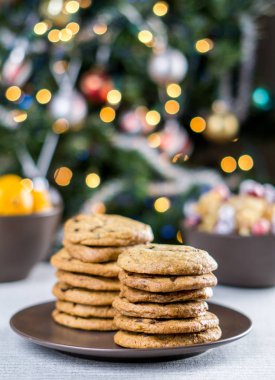 Fırından yeni çıkmış bulanık Noel ağacı arka plan ile bir tabloda çikolatalı kurabiye.