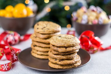 Fırından yeni çıkmış bulanık Noel ağacı arka plan ile bir tabloda çikolatalı kurabiye.