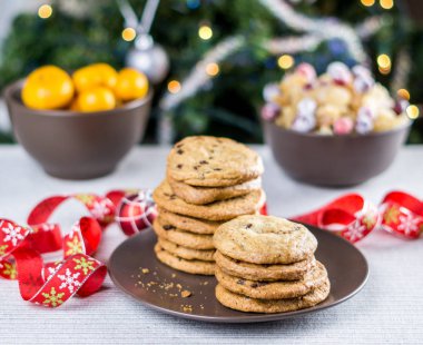 Fırından yeni çıkmış bulanık Noel ağacı arka plan ile bir tabloda çikolatalı kurabiye.