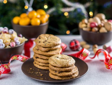 Fırından yeni çıkmış bulanık Noel ağacı arka plan ile bir tabloda çikolatalı kurabiye.