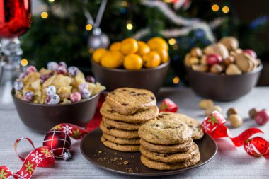 Fırından yeni çıkmış bulanık Noel ağacı arka plan ile bir tabloda çikolatalı kurabiye.
