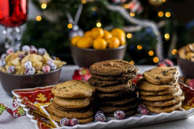 Fırından yeni çıkmış bulanık Noel ağacı arka plan ile bir tabloda çikolatalı kurabiye.