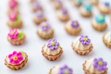 Bir sürü beyaz yüzey üzerinde yapay cupcakes sığ derinliği alan arka plan ile.