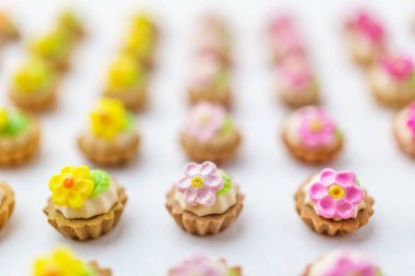 Bir sürü beyaz yüzey üzerinde yapay cupcakes sığ derinliği alan arka plan ile.