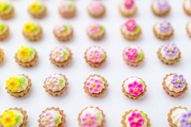 Bir sürü beyaz yüzey üzerinde yapay cupcakes sığ derinliği alan arka plan ile.
