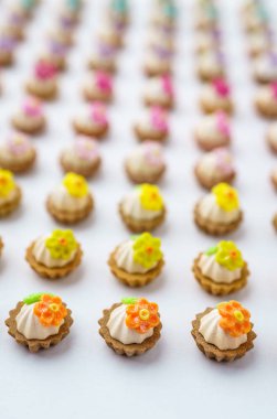 Bir sürü beyaz yüzey üzerinde yapay cupcakes sığ derinliği alan arka plan ile.
