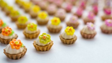 Bir sürü beyaz yüzey üzerinde yapay cupcakes sığ derinliği alan arka plan ile.