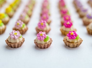 Bir sürü beyaz yüzey üzerinde yapay cupcakes sığ derinliği alan arka plan ile.