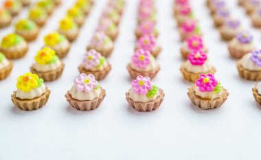 Bir sürü beyaz yüzey üzerinde yapay cupcakes sığ derinliği alan arka plan ile.