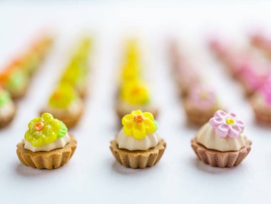 Bir sürü beyaz yüzey üzerinde yapay cupcakes sığ derinliği alan arka plan ile.