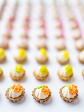 Bir sürü beyaz yüzey üzerinde yapay cupcakes sığ derinliği alan arka plan ile.