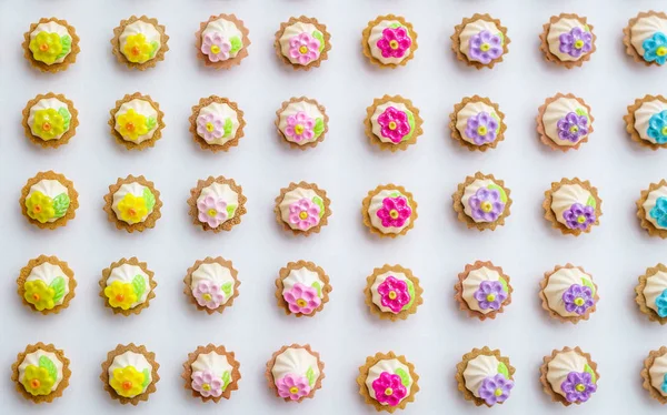 Una gran cantidad de cupcakes artificiales en la superficie blanca con poca profundidad de fondo de campo . — Foto de Stock