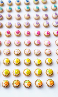 Bir sürü beyaz yüzey üzerinde yapay cupcakes sığ derinliği alan arka plan ile.