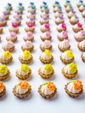 Bir sürü beyaz yüzey üzerinde yapay cupcakes sığ derinliği alan arka plan ile.