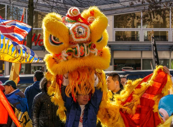 VANCOUVER, CANADÁ - 18 de febrero de 2014: La gente en traje de león amarillo en el desfile de Año Nuevo chino en Vancouver Chinatown . — Foto de Stock