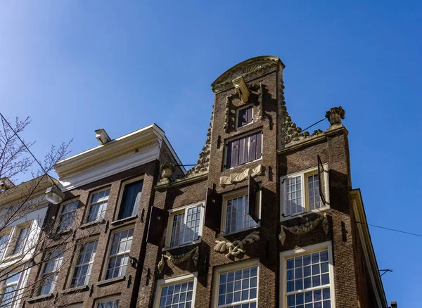 AMSTERDAM, PAÍSES BAJOS - 20 de marzo de 2018: Vista desde el ángulo bajo de las casas estrechas de Ámsterdam . — Foto de Stock