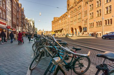 Amsterdam, Hollanda - 20 Mart 2018: Bisiklet Amsterdam Caddesi'nde güneşli bahar günü.