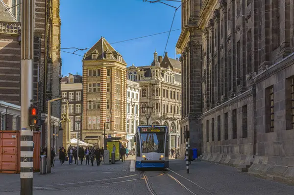 AMSTERDAM, PAÍSES BAJOS - 20 de marzo de 2018: tranvía en las calles estrechas de Ámsterdam en el soleado día de primavera . — Foto de Stock