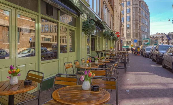 Amsterdam, Hollanda - 20 Mart 2018: Amsterdam Caddesi'nde güneşli bahar günü çiçekleri tablolarla.