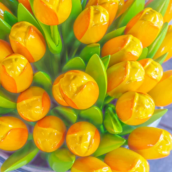 Artificial yellow tulips close up a background with the blossoming tulips. — Stock Photo, Image