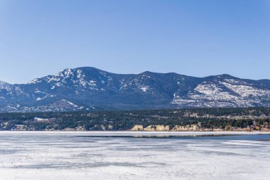 Güzel Kolombiya gölü, buz mavisi gökyüzü, kayalık dağlar, Britanya Kolombiyası Kanada manzarası.