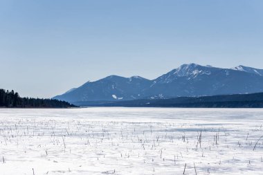 Güzel Kolombiya gölü, buz mavisi gökyüzü, kayalık dağlar, Britanya Kolombiyası Kanada manzarası.