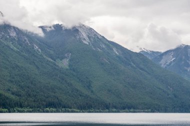 Chilliwack Gölü 'nün uzak vadisindeki dağ manzarası güneşli bir gün.