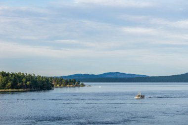 SIDNEY, CANADA - 14 HAZİRAN 2019: Vancouver Adası 'ndan Vancouver Boğazı manzaralı tekne bulutlu Britanya Kolombiyası Kanada