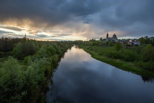 Güzel fırtına bulutlarının yansıtıldığı geniş Rus nehri, sol kıyıdan yoğun bir orman büyür, ve sağda köy ve tapınağı görebilirsiniz. Su bulut tarafından çok güzel yansıtılır. Russ 'ın doğası