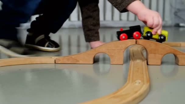 Malý chlapec hraje s železniční dřevěné — Stock video
