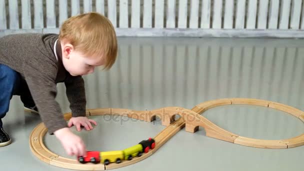 Niño jugando con el ferrocarril de madera — Vídeos de Stock