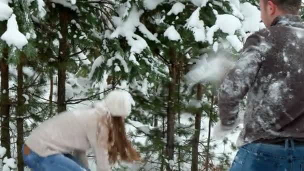 Un tipo con una chica jugando bolas de nieve — Vídeo de stock