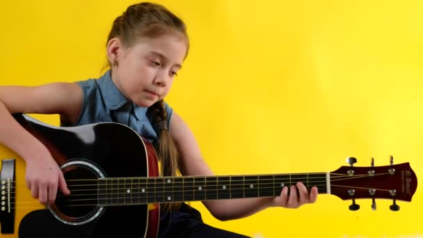 Блондинка с голубыми глазами играет на гитаре — стоковое видео
