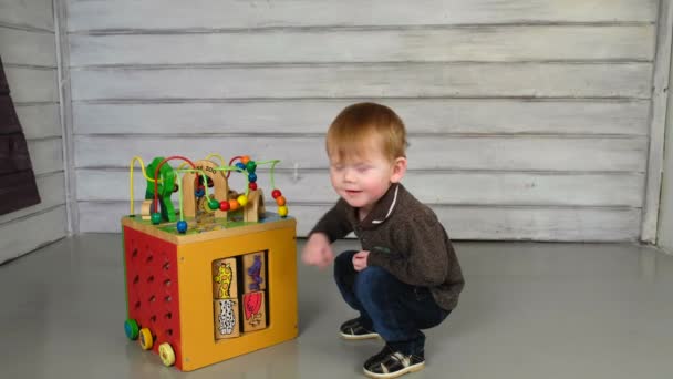 Lindo niño sentado en el suelo y jugando — Vídeos de Stock