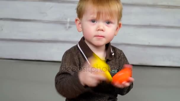 Маленький мальчик играет с деревянной железной дорогой — стоковое видео