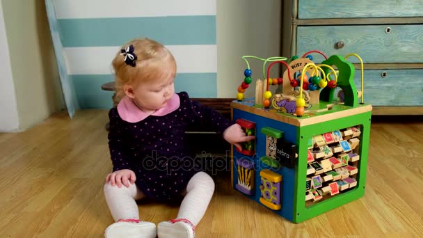 Schattig klein meisje zittend op de vloer en spelen — Stockvideo