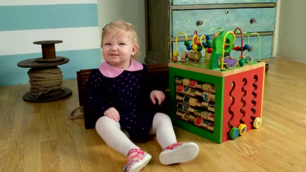 Cute little girl sitting on the floor and playing — Stock Video