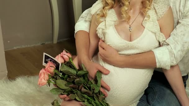Счастливые будущие родители смотрят на фото беременности на ультразвуке — стоковое видео
