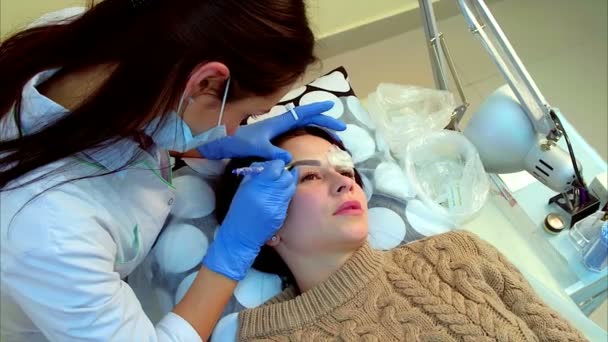 Kosmetikerin macht permanentes Make-up der Wimpern. — Stockvideo