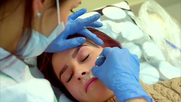 Kosmetolog att göra permanent makeup av ögonfrans. — Stockvideo