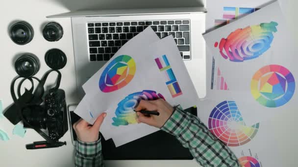 Vista desde arriba. Man es un fotógrafo que trabaja en su tableta gráfica en un estudio de diseño . — Vídeos de Stock