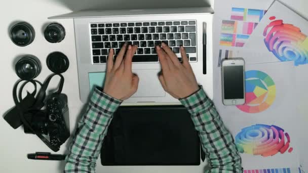 Vista desde arriba. Man es un fotógrafo que trabaja en su tableta gráfica en un estudio de diseño . — Vídeos de Stock