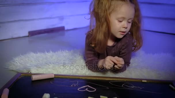 Kleines Mädchen zeichnet mit Kreide auf Tafel — Stockvideo