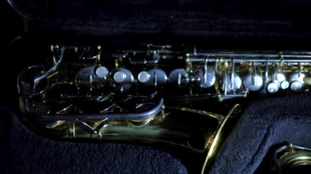 Saxophon auf dunklem Hintergrund im Koffer — Stockvideo
