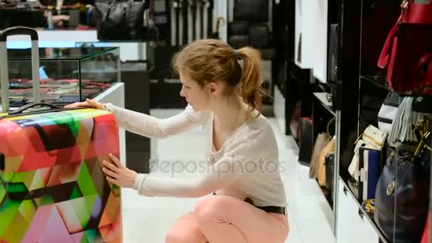 Una chica hermosa escoge una bolsa. tienda de bolsas Tienda de moda — Vídeos de Stock