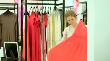 Elbise giyim mağazasında insanlar ve moda, gülümseyerek ve trying dışarı mutlu bir genç kadın portresi