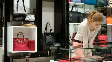 Güzel bir kız bir torba alır. çanta Dükkanı moda mağaza