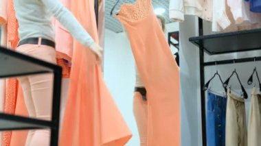 Elbise giyim mağazasında insanlar ve moda, gülümseyerek ve trying dışarı mutlu bir genç kadın portresi