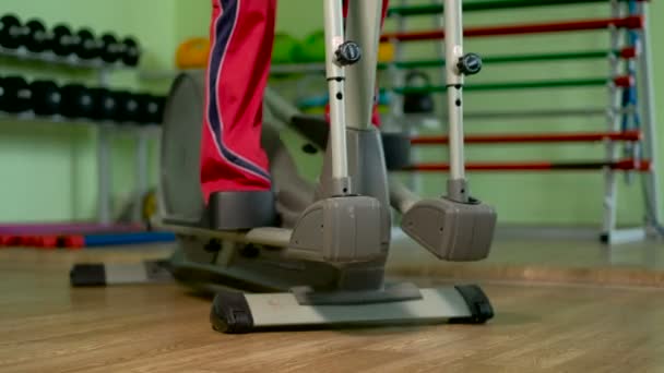 An elderly woman on an elliptical trainer in a gym 4k — Stock Video